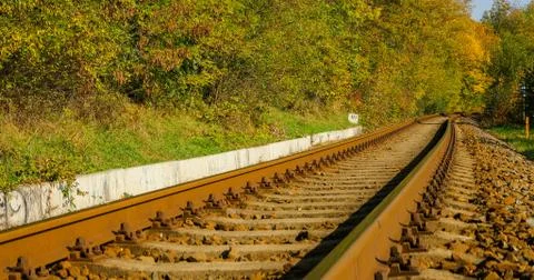 A close-up view of the large screws securing the train tracks during a sunny  Stock-Fotos