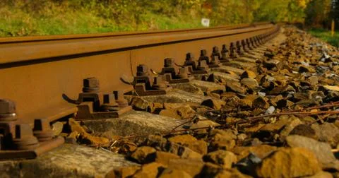 A close-up view of the large screws securing the train tracks during a sunny  Stock-Fotos