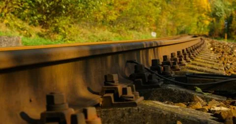 A close-up view of the large screws securing the train tracks during a sunny  Stock-Fotos
