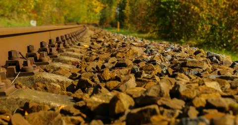 A close-up view of the large screws securing the train tracks during a sunny  Photos