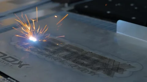 Close up view: laser engraving machine burns logo on sheet of metal Stock Footage 344332349