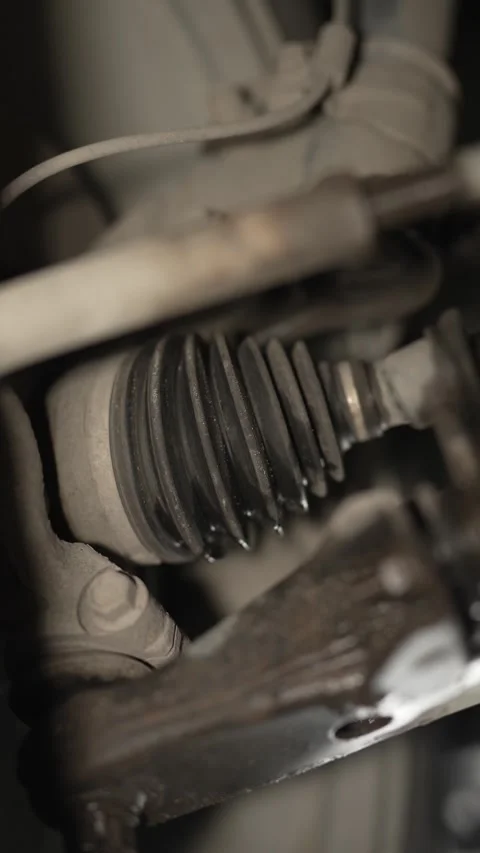 A close-up view of a leaking or damaged rubber CV joint boot on a car axle. Stock Footage 340977325