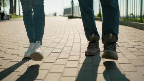 Close-Up View Of Legs Walking On Interlocked Path In Casual Footwear Stock Footage 301692253
