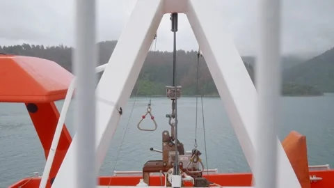Close-up view of lifeboat davit hooks swaying gently in the wind above Stock Footage 299957813