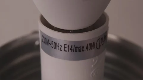 Close up view of light bulb base inside socket with technical text 스톡 동영상 347068971