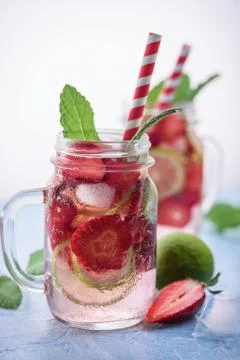 Close up view on lime and strawberry detox drink in glass mason jars on a blu Stock Photos