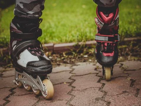Close-up view at the in-line skates wearing on mother and children legs, people  Stock Photos