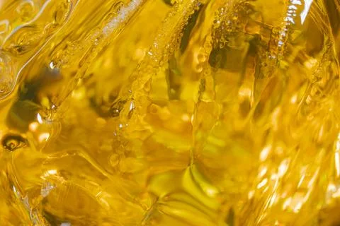 Close up view of a liquid with bubbles and textures under bright light duri.. Stock Photos