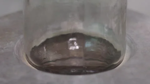 Close Up View of Liquid Mercury Swirling Inside a Glass Laboratory Cylinder Stock Footage 339630536