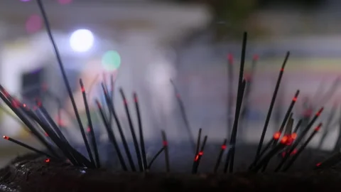 Close-up view of lit incense sticks at Buddhist temple, glowing embers at tips Stock Footage 265396160
