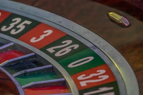 Close-up view of a lit roulette wheel with alternating red and black numbered Stock Photos