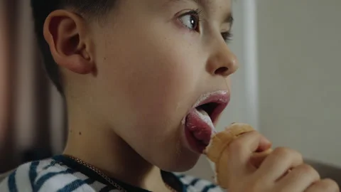 Close up view of a little boy kid holding ice cream in hands, licking with Stock Footage 272510327