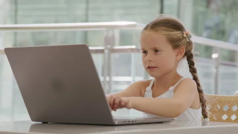 Close-up view of little girl using laptop while studying remotely Stock Footage 235487439