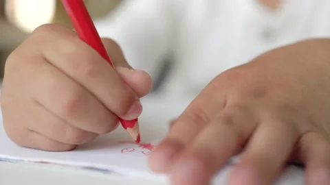 Close-up view of little hands drawing with red pen on a white paper. Stock Footage 194509874