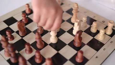 Close-up view of little hands moving a chess figure on chessboard Stock Footage 194336080