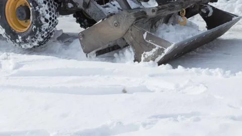 Close View of Loader Blade Pushing Deep Snow in Residential Yard Stock Footage 347884643