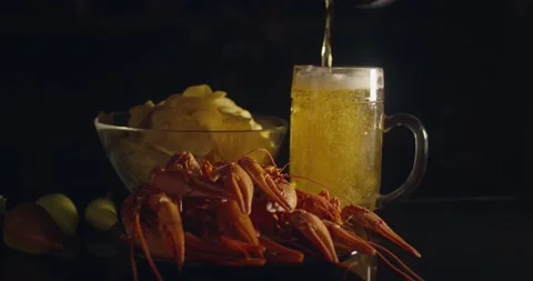 Close up view of lobsters with bear pouring in glass and chips on background Stock Footage 142735934