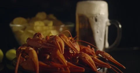 Close up view of lobsters with bear pouring in glass and chips on background Stock Footage 142735964