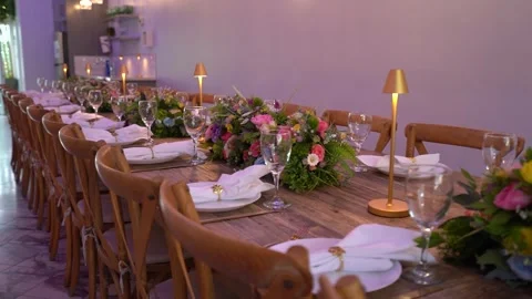 Close view of a long dinner table with flowers and gold lamps Stock Footage 345550735