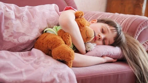 Close up view of long-haired sleeping little girl, her mother comes and kisses Video stock 99312068