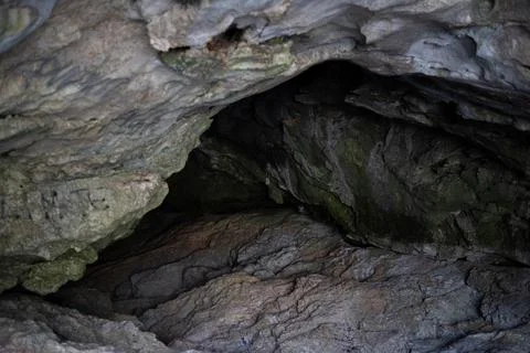 Close-up view looking into the dark opening of a rocky cave Fotos Stock