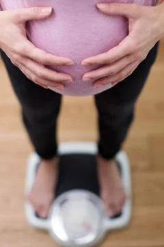 Close Up View Looking Down On Pregnant Woman Standing On Bathroom Scales 写真素材