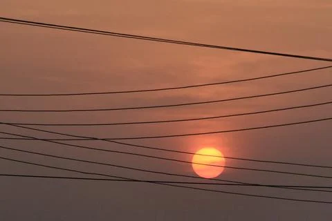 Close up view of low setting full round sun with electricity and Stock Photos