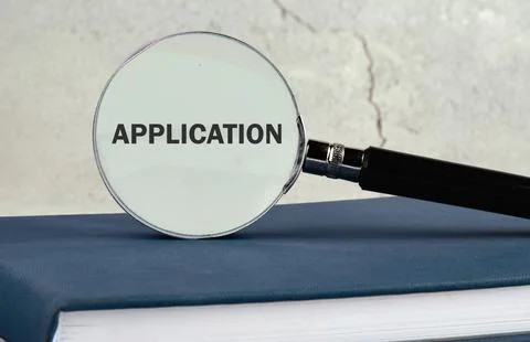 Close up view of a magnifying glass positioned over a blue book with the word Stock Photos
