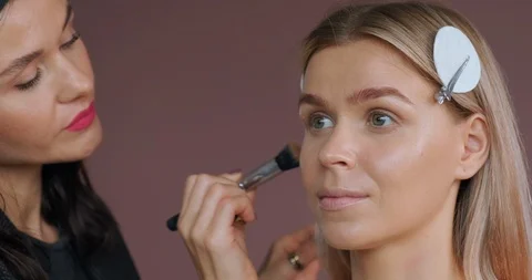 Close-up view make-up artist’s hand applying eye shadow special brush woman Stock Footage 120149105