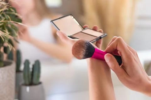Close up view of make up bronzer and brush shaking the excess of loose powder Foto stock