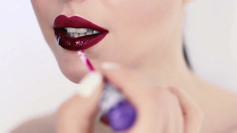 Close up view of a makeup artist applying lipstick on model's lips. Stock Footage 125614539
