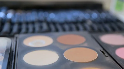 Close up view of makeup brush moving over skin and eyeshadow color palette Stock Footage 74582556