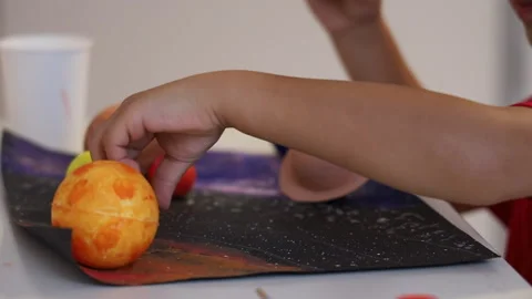 Close up view of making a 3D solar system on a list of paper. Home education. Stock Footage 165728948