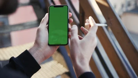 Close up view of male hand holding vertically modern smartphone with green Stock Footage 105260602