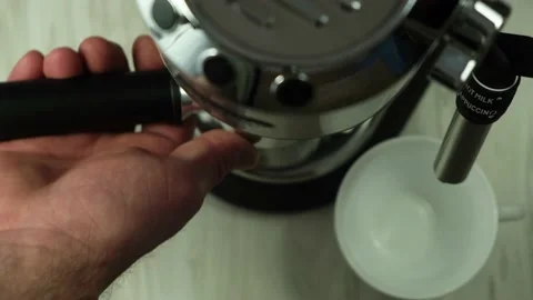 Close-up view of a male hand inserting a portafilter filled with ground coffe Stock Footage 152872359