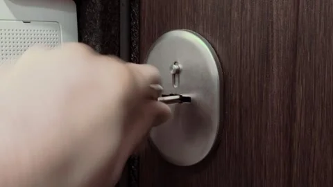 Close-up view male hand inserting metal key into door lock mechanism, turning to Stock Footage 344844635