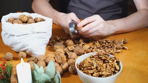 Close up view of male hands cracking walnuts with a nutcracker Stock Footage 121479264