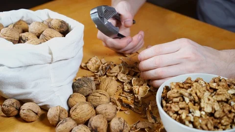 Close up view of male hands cracking walnuts with a nutcracker Stock Footage 121479399