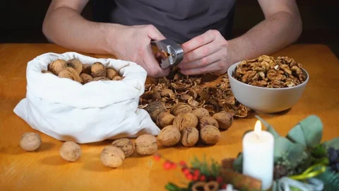 Close up view of male hands cracking walnuts with a nutcracker Stock Footage 121479471