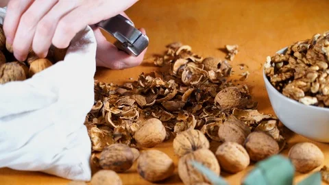 Close up view of male hands cracking walnuts with a nutcracker Stock Footage 121479812