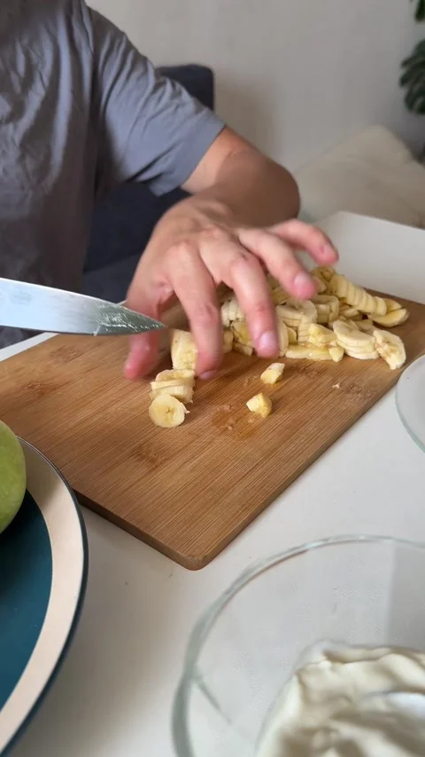 Close-up view of male hands slicing banana on cutting board. Homemade fruit Stock Footage 337358385