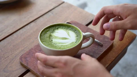 Close-up view of male hands taking a mug of matcha Stock Footage 236699016