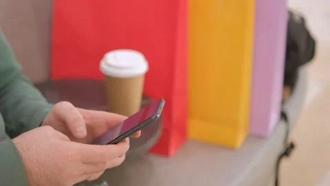 Close view of the male hands using smartphone, texting. Young lady standing at Stock Footage 232492933