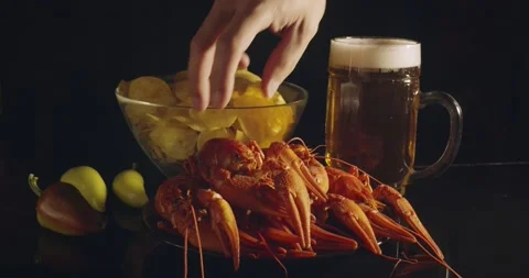 Close up view of man arm taking lobsters with bear and chips on background Stock Footage 142736217