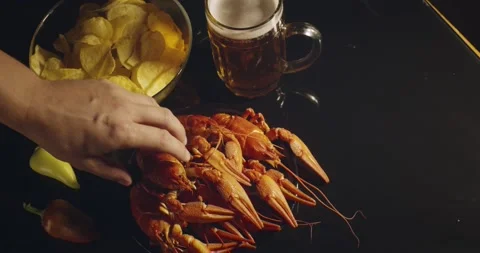 Close up view of man arm taking lobsters with bear and chips on background Stock Footage 142736305