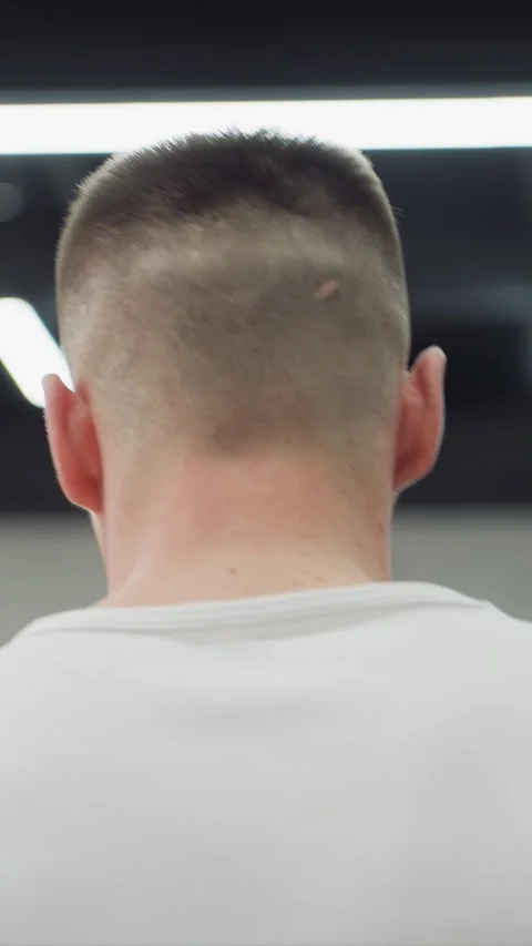 Close up view of man back and neck in indoor setting with bright artificial 库存影片 348116647