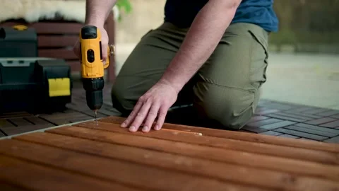Close-up view of a man drilling holes in a woden panel outdoors 스톡 동영상 197390045