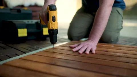 Close-up view of a man drilling holes in a woden panel outdoors 스톡 동영상 202048295