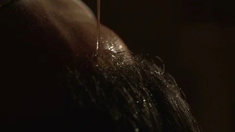 Close-up view of the man forehead. The oil is poured on his face. The spa Stock Footage 82611853