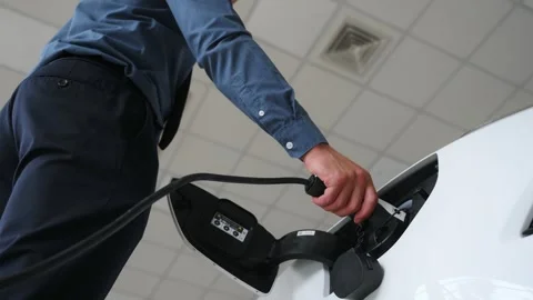 Close up view of man hand that is plugins in charging cable into electric car Vídeo Stock 299714246